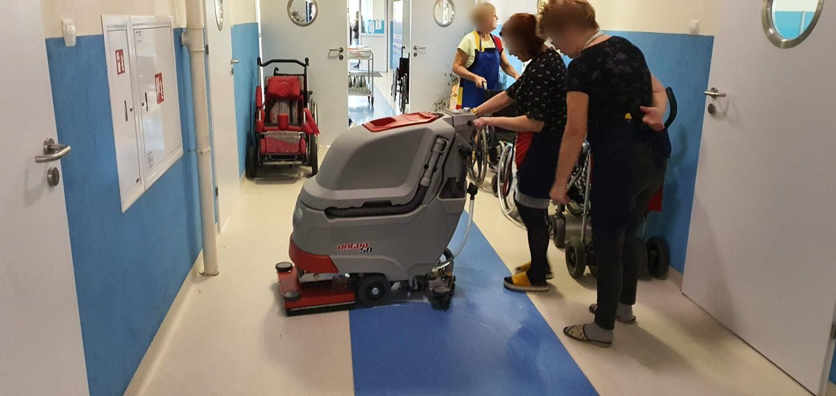 Antea 50 BTO na korytarzu placówki opiekuńczej — pad orbitalny na posadzce PCV, obok personel
