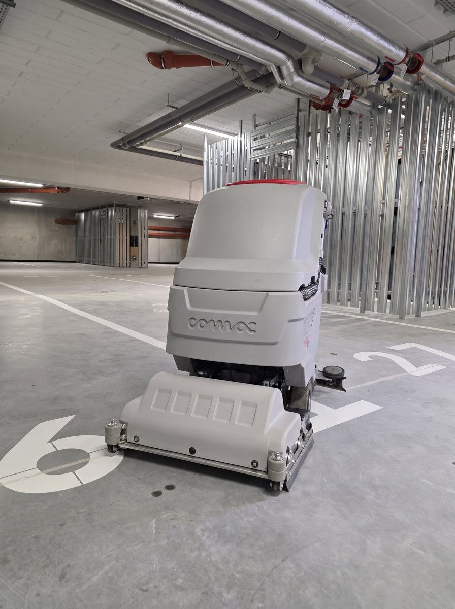 Antea 50 BTS na posadzce parkingu podziemnego — głowica walcowa zbiera piasek i drobne zanieczyszczenia