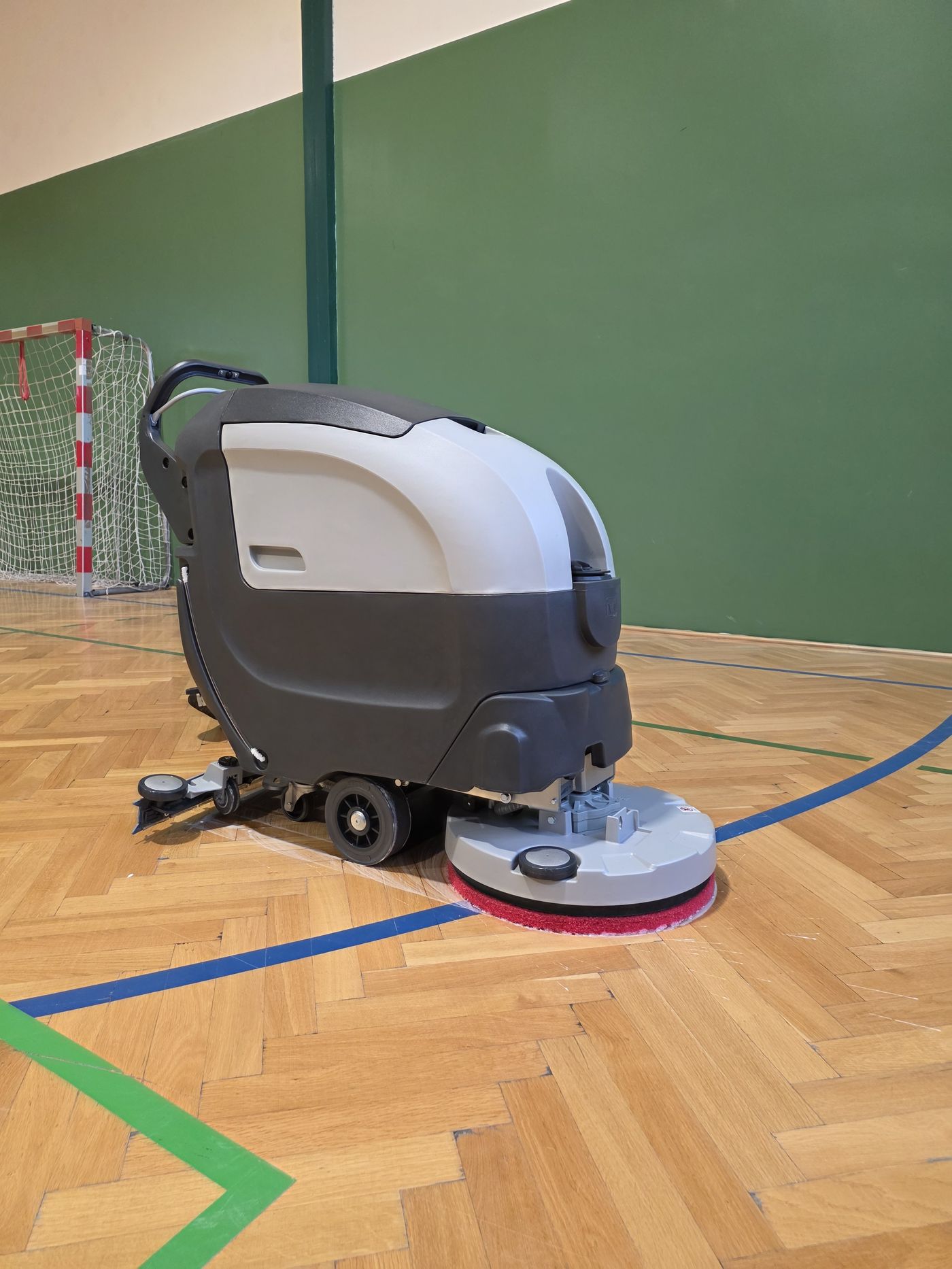 Fabula 50 BT z boku w sali gimnastycznej — cztery koła i podniesiona głowica szczotkowa