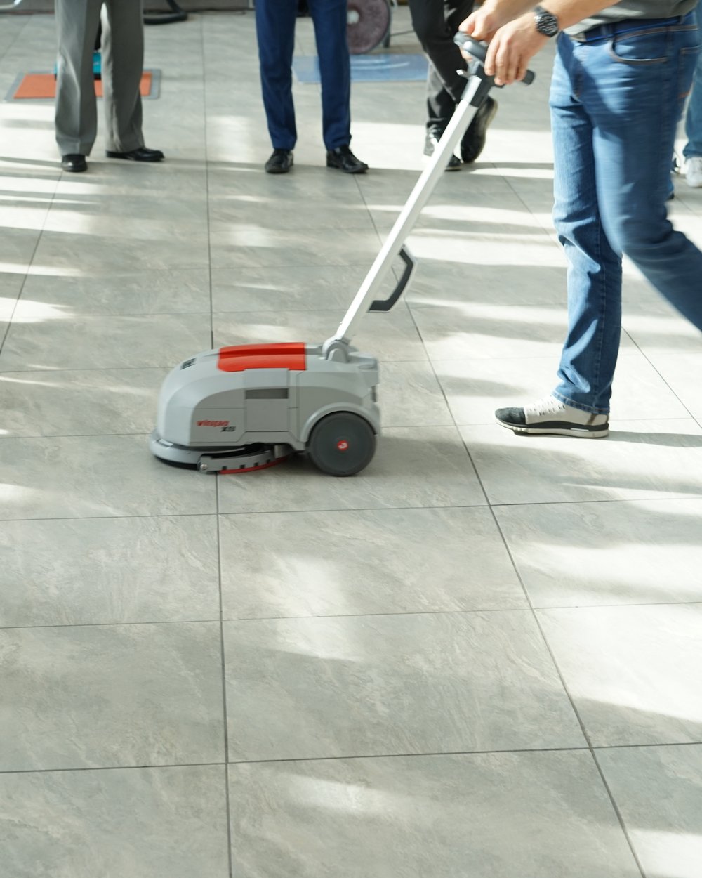 Pokaz Vispy XS przed grupą klientów — mycie posadzki w hali prezentacyjnej