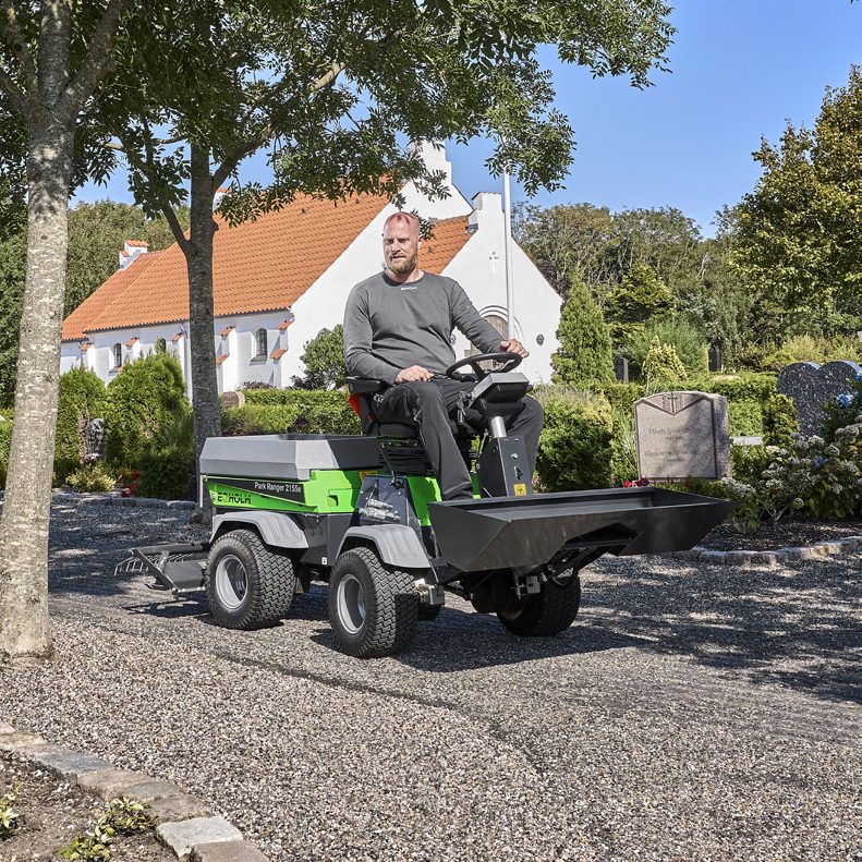 Park Ranger 2155e przewozi narzędzia w skrzyni ładunkowej po alejce parkowej