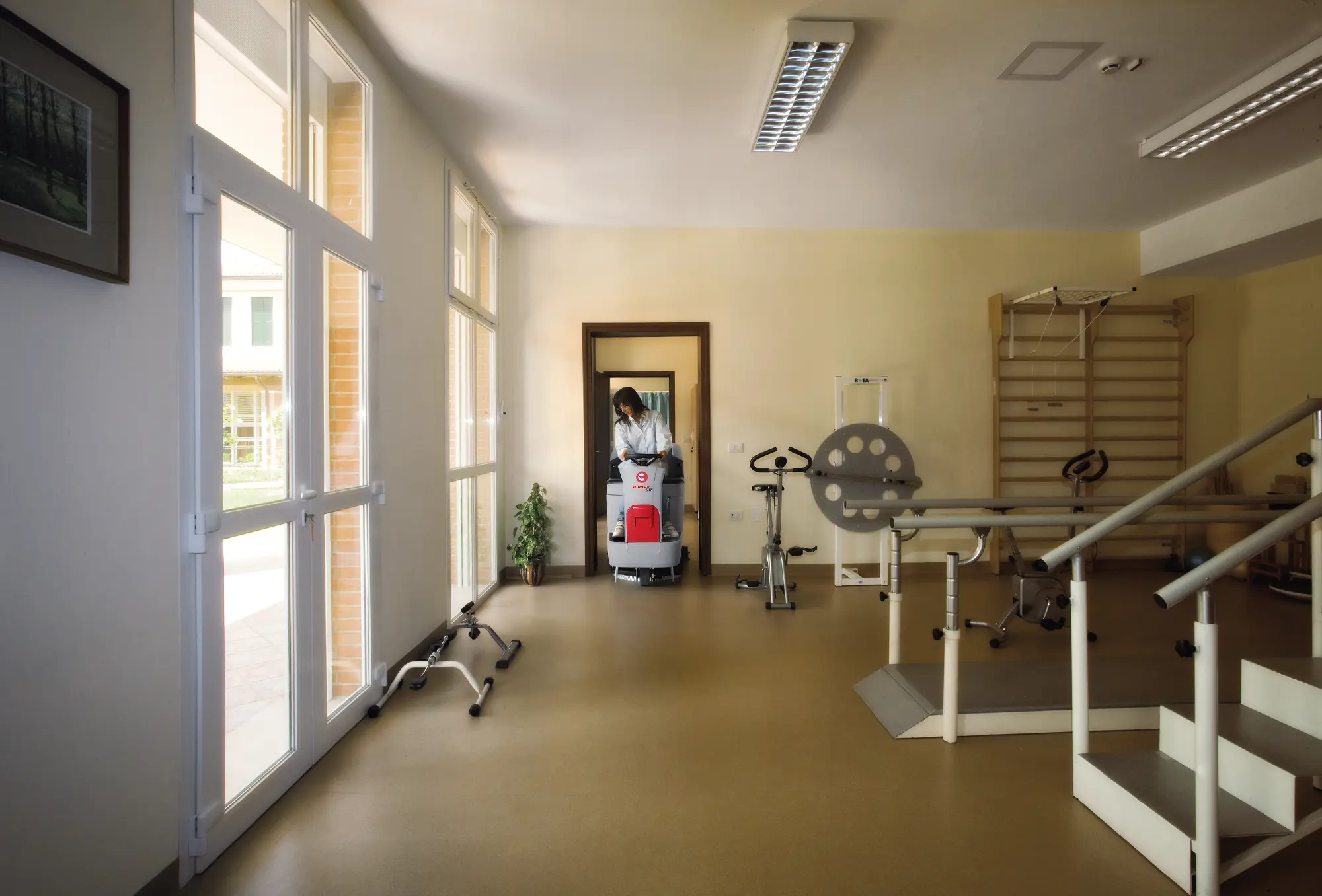 Comac Innova 85 B przejeżdża przez standardowe drzwi do sali rehabilitacyjnej